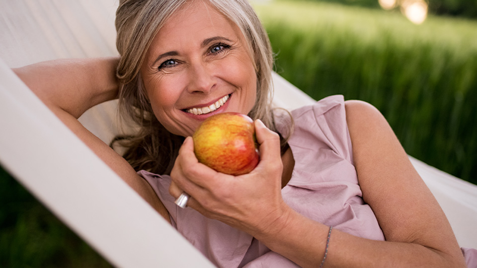 woman with apple smiling